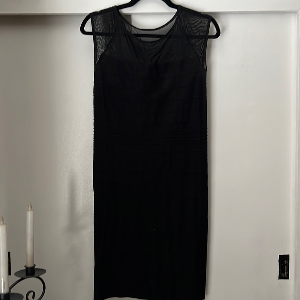 Bebe form fitting black dress with a sheer top